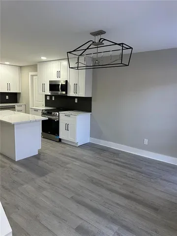 a kitchen with kitchen island a counter top space appliances and cabinets