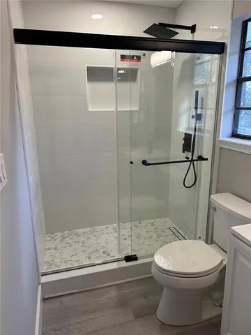 a bathroom with a toilet and a shower