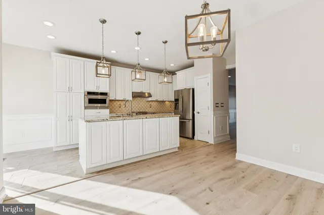 a large kitchen with a lot of cabinets and wooden floor