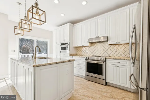 a kitchen with stainless steel appliances granite countertop a stove and a sink
