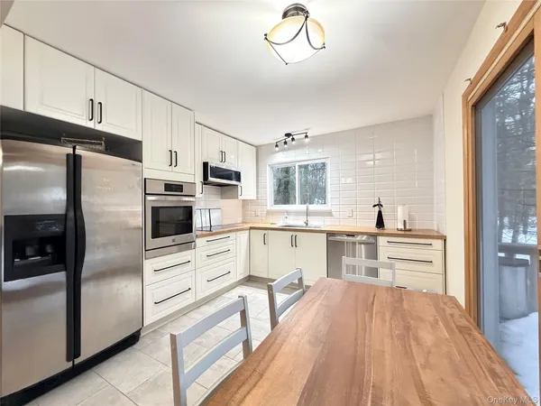 a kitchen with stainless steel appliances a refrigerator sink and microwave