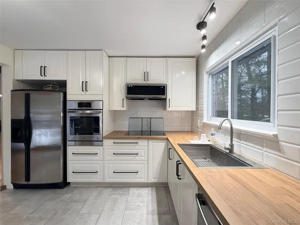 a kitchen that has a sink and a stove top oven