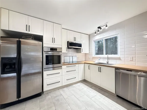 a kitchen with white cabinets and stainless steel appliances