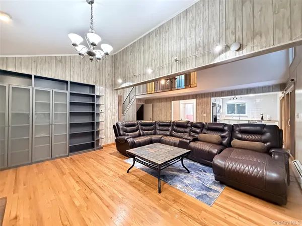 a living room with furniture a chandelier and a wooden floor