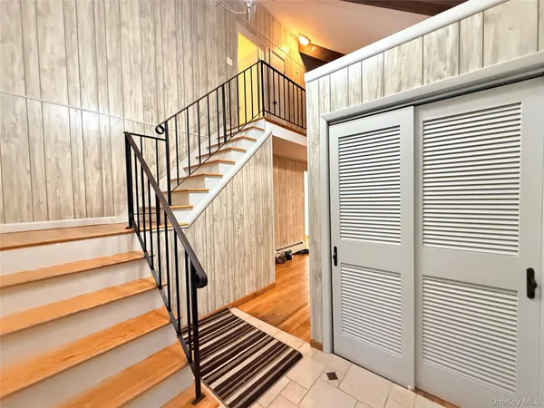 a view of staircase with railing and a window