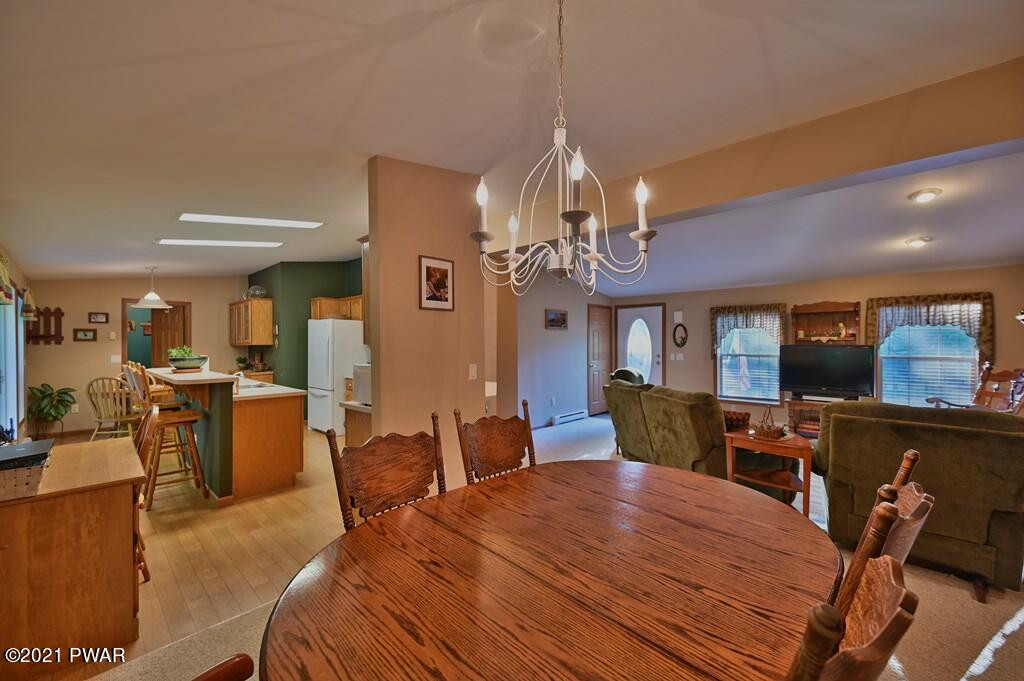417 Northgate Road Lake Ariel, PA 18436 - Photo 11 of 91 a view of a dining room with furniture a chandelier and wooden floor