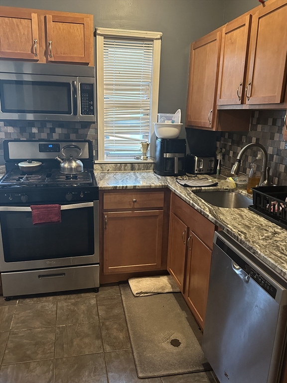 48 E Street Lowell, MA 01851 - Photo 12 of 14 a kitchen with a sink stove and microwave