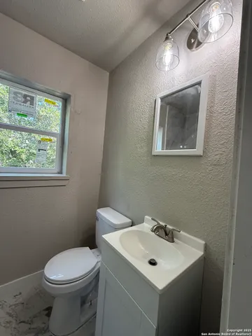 a bathroom with a toilet sink and mirror