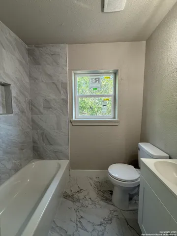 a bathroom with a toilet and bathtub