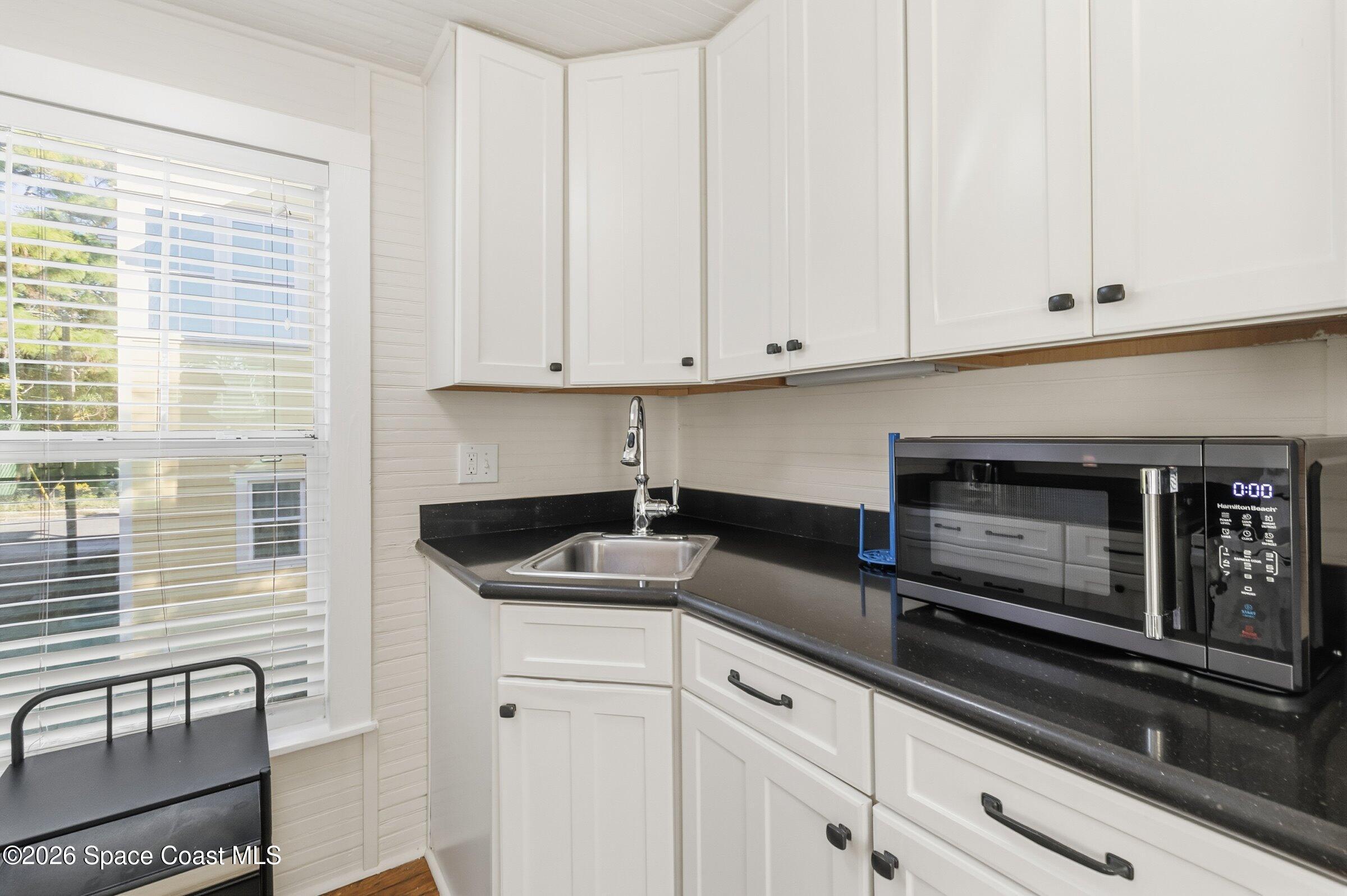 11 Mitchell Street Cocoa, FL 32922 - Photo 135 of 159 a kitchen with granite countertop white cabinets and white appliances