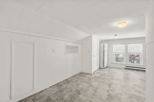 an empty room with windows and cabinet