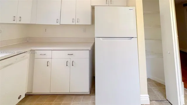 a view of a refrigerator with white cabinets