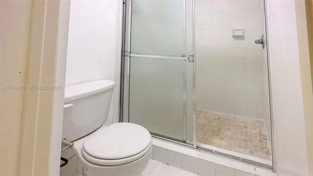 a white toilet next to a bathroom