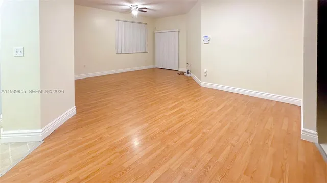a view of an empty room with wooden floor