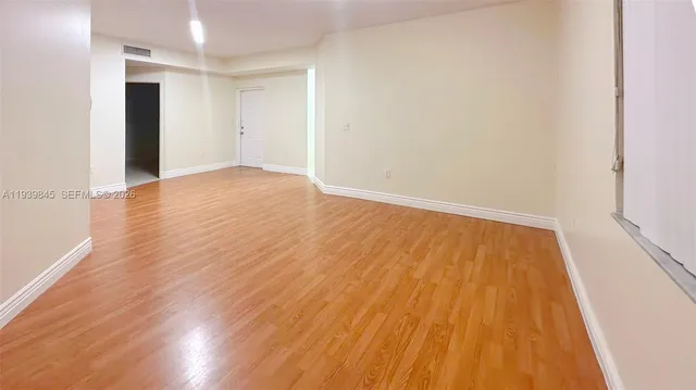 a view of an empty room with wooden floor