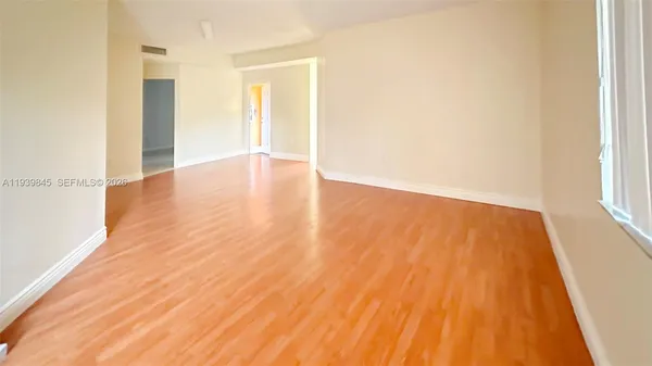 a view of room with window and wooden floor