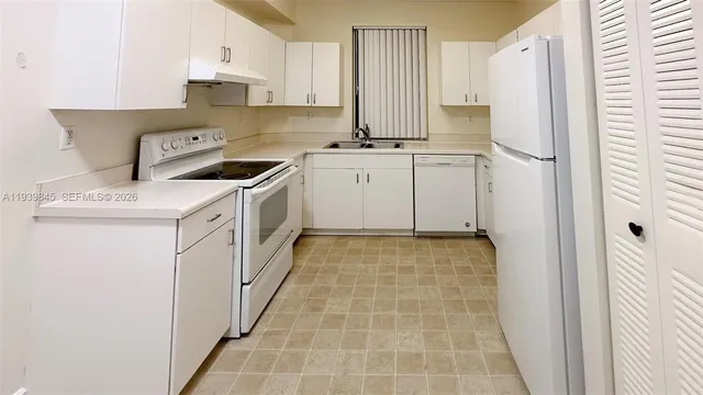 a kitchen with a stove a refrigerator and a sink