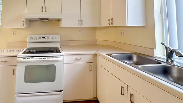 a kitchen with white cabinets and white appliances