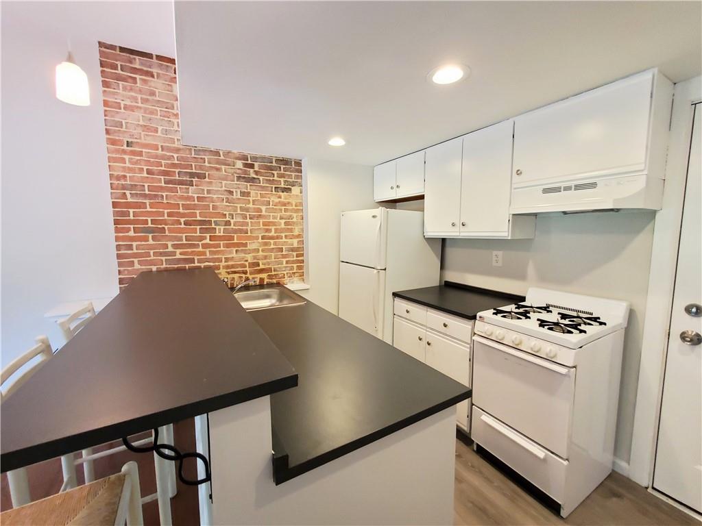 352 North Craig Street, Unit 5 Pittsburgh, PA 15213 - Photo 9 of 10 a kitchen with a stove cabinets and a refrigerator