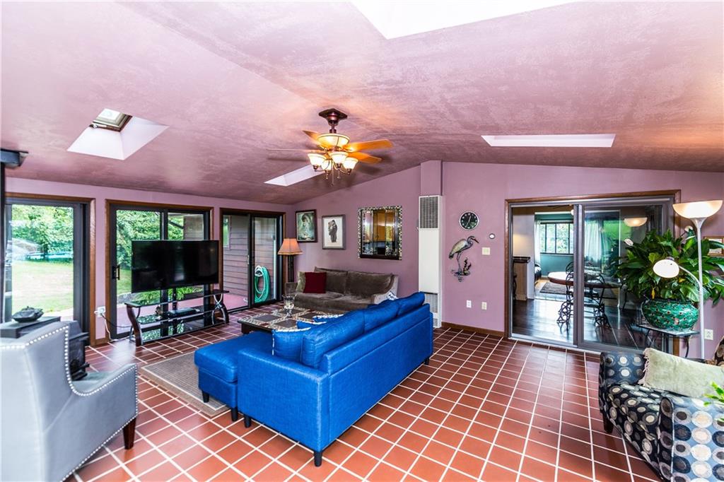 2045 McKees Rocks Road McKees Rocks, PA 15136 - Photo 14 of 25 Enormous, fully-insulated family room with dedicated gas furnace, Spanish tile flooring, cathedral ceiling, ceiling fan/light, 4 skylights, wood burner, 3 walls of windows/sliding doors overlooking lush gardens/grape arbor/electric pond/pergola with benched seating and lights/above-ground pool & sun deck/barn shed with loft/6+ vehicle detached garage with separate driveway/wrap-around deck!