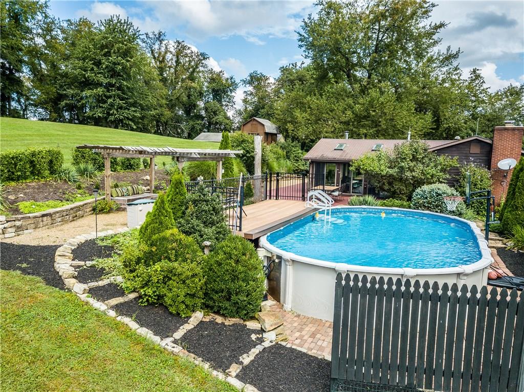 2045 McKees Rocks Road McKees Rocks, PA 15136 - Photo 22 of 25 View of 18X33, above-ground pool and sun deck, pergola with bench seating and lighting, landscaping, barn shed, roof of detached garage and property. Magnificent, unique!