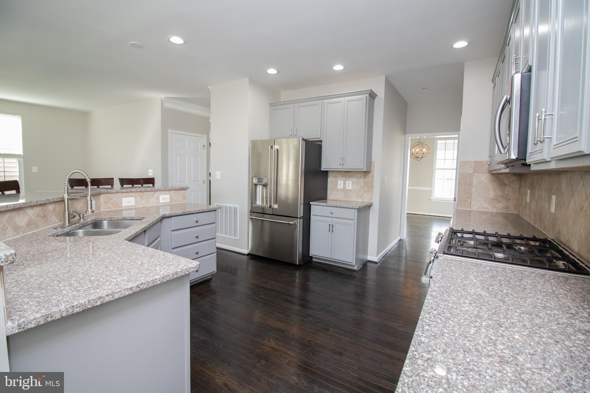 25257 Doolittle Lane Chantilly, VA 20152 - Photo 12 of 52 a kitchen with stainless steel appliances granite countertop a sink stove and refrigerator