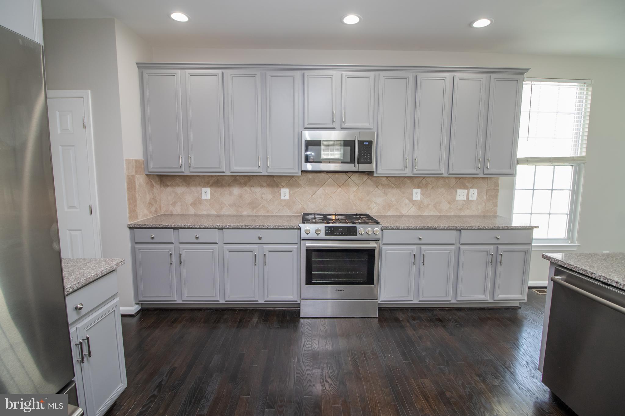 25257 Doolittle Lane Chantilly, VA 20152 - Photo 13 of 52 a kitchen with granite countertop white cabinets and stainless steel appliances