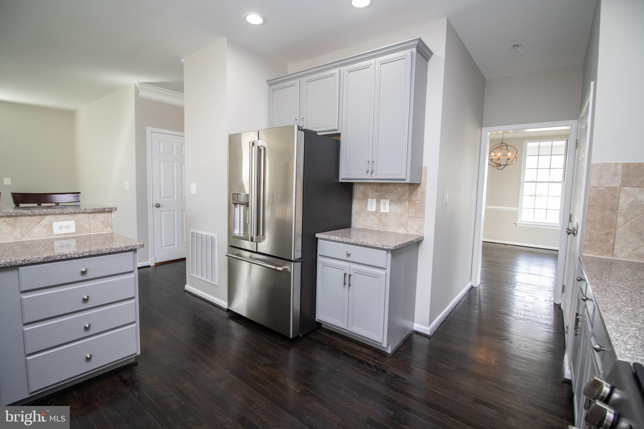 25257 Doolittle Lane Chantilly, VA 20152 - Photo 14 of 52 a kitchen with white cabinets and stainless steel appliances