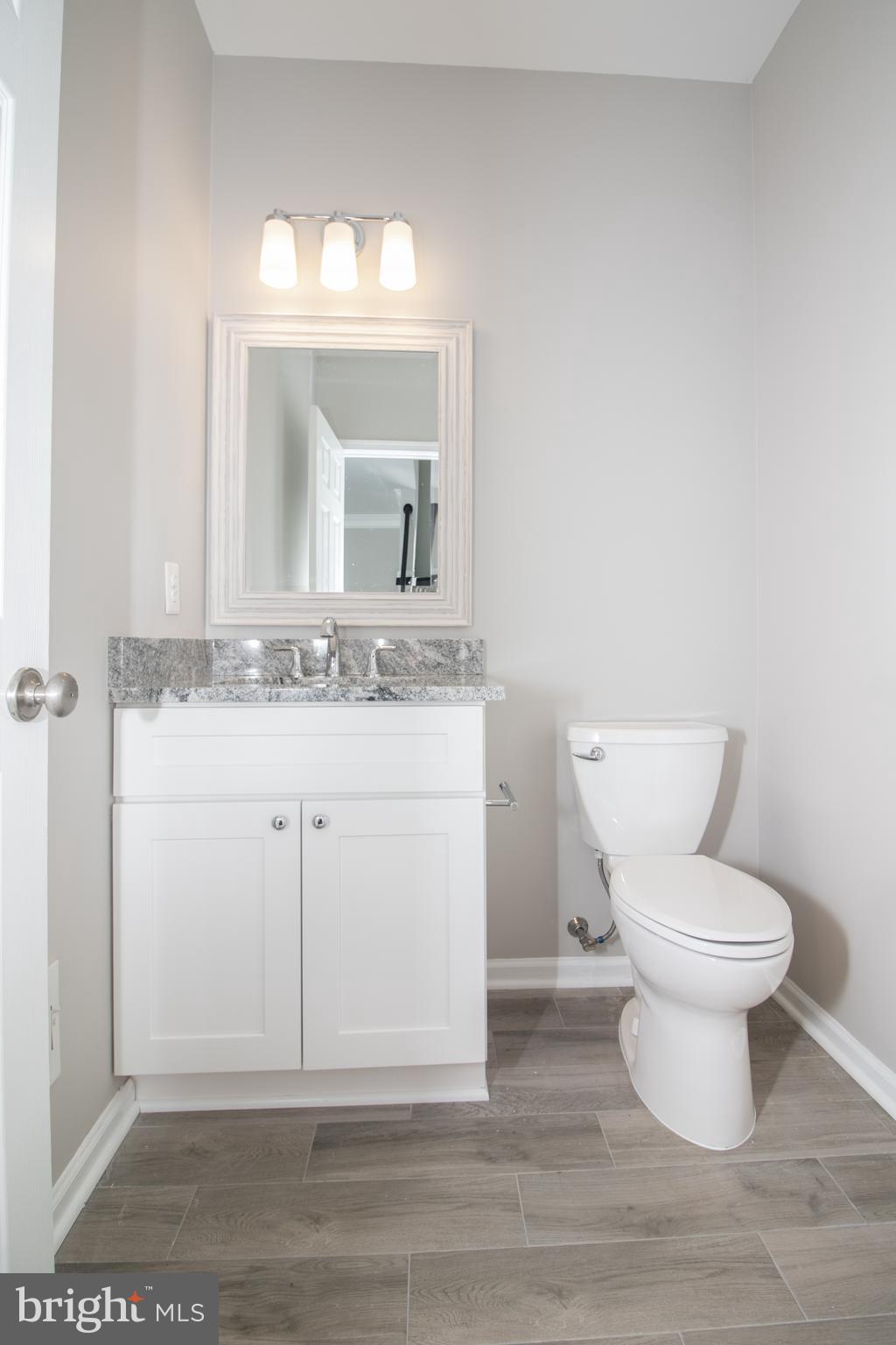 25257 Doolittle Lane Chantilly, VA 20152 - Photo 21 of 52 a bathroom with a granite countertop toilet a sink and mirror