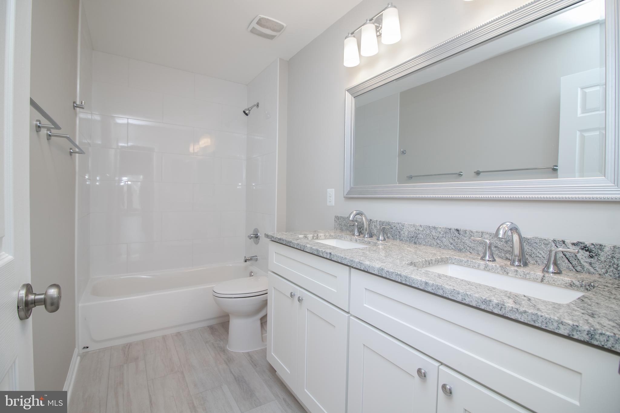 25257 Doolittle Lane Chantilly, VA 20152 - Photo 28 of 52 a bathroom with a granite countertop sink a toilet and shower