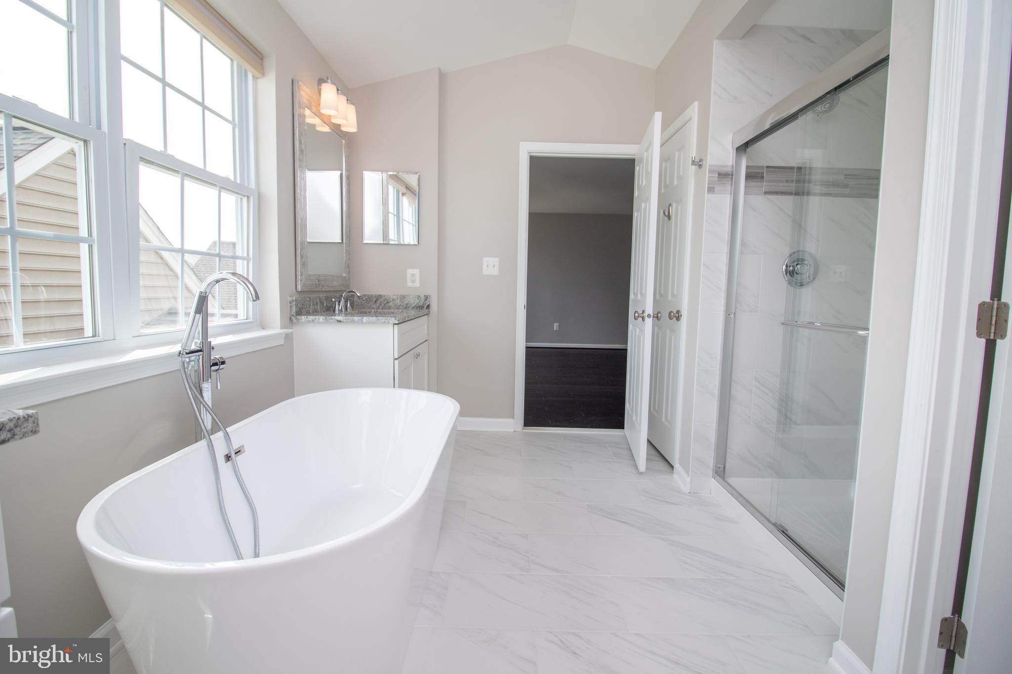 25257 Doolittle Lane Chantilly, VA 20152 - Photo 37 of 52 a white bath tub sitting in a spacious bathroom next to a window