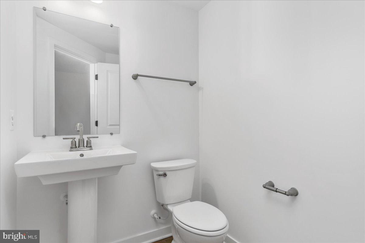 711 Iron Frg Road, Unit A Frederick, MD 21702 - Photo 13 of 18 a bathroom with a toilet a sink and mirror