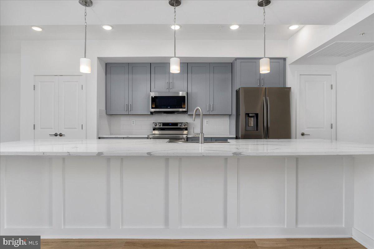 711 Iron Frg Road, Unit A Frederick, MD 21702 - Photo 5 of 18 a kitchen with stainless steel appliances a refrigerator a sink and a stove