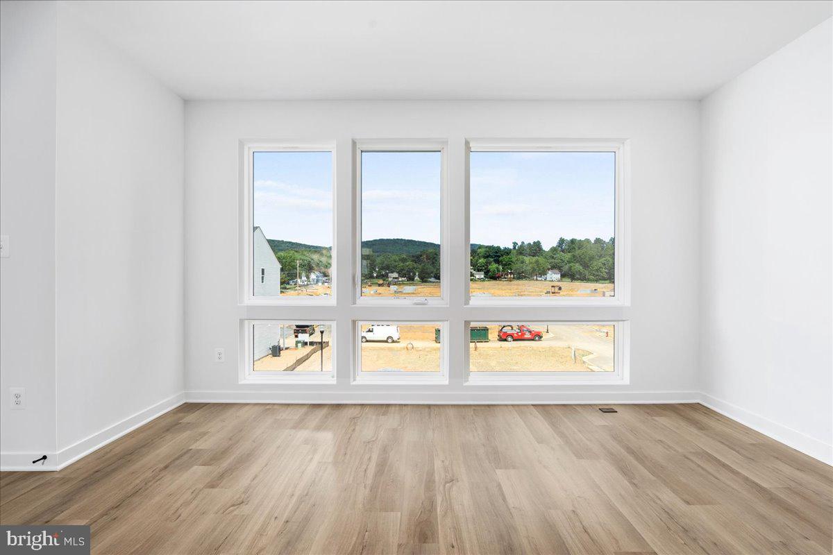 711 Iron Frg Road, Unit A Frederick, MD 21702 - Photo 8 of 18 an empty room with wooden floor and outdoor view