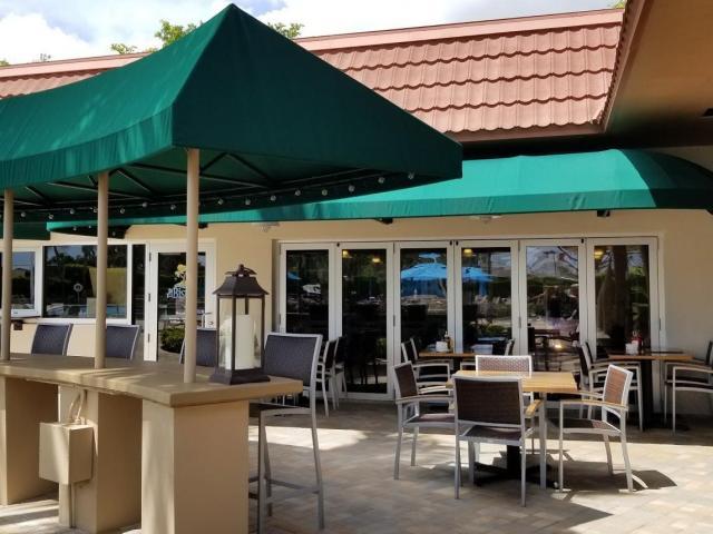 402 Monaco Way, Unit I Delray Beach, FL 33446 - Photo 17 of 25 a view of a patio with table and chairs under an umbrella