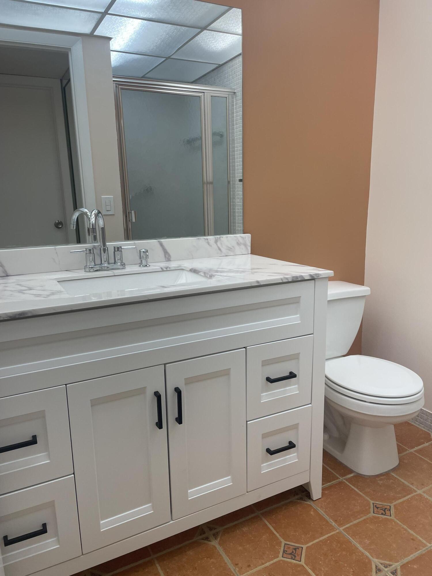 402 Monaco Way, Unit I Delray Beach, FL 33446 - Photo 24 of 25 a bathroom with a granite countertop toilet and a sink