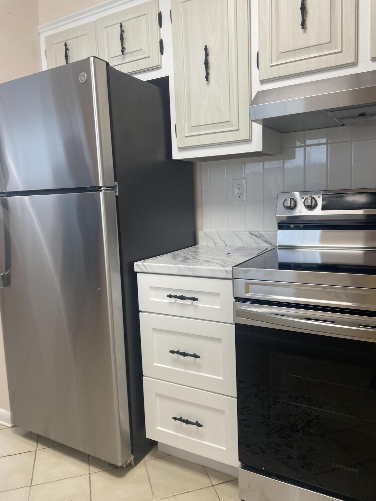 402 Monaco Way, Unit I Delray Beach, FL 33446 - Photo 4 of 25 a kitchen with stainless steel appliances a refrigerator and cabinets