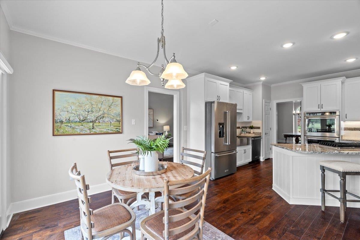 10440 Ansley Cove Collierville, TN 38017 - Photo 12 of 40 a view of a dining room with furniture a chandelier and wooden floor