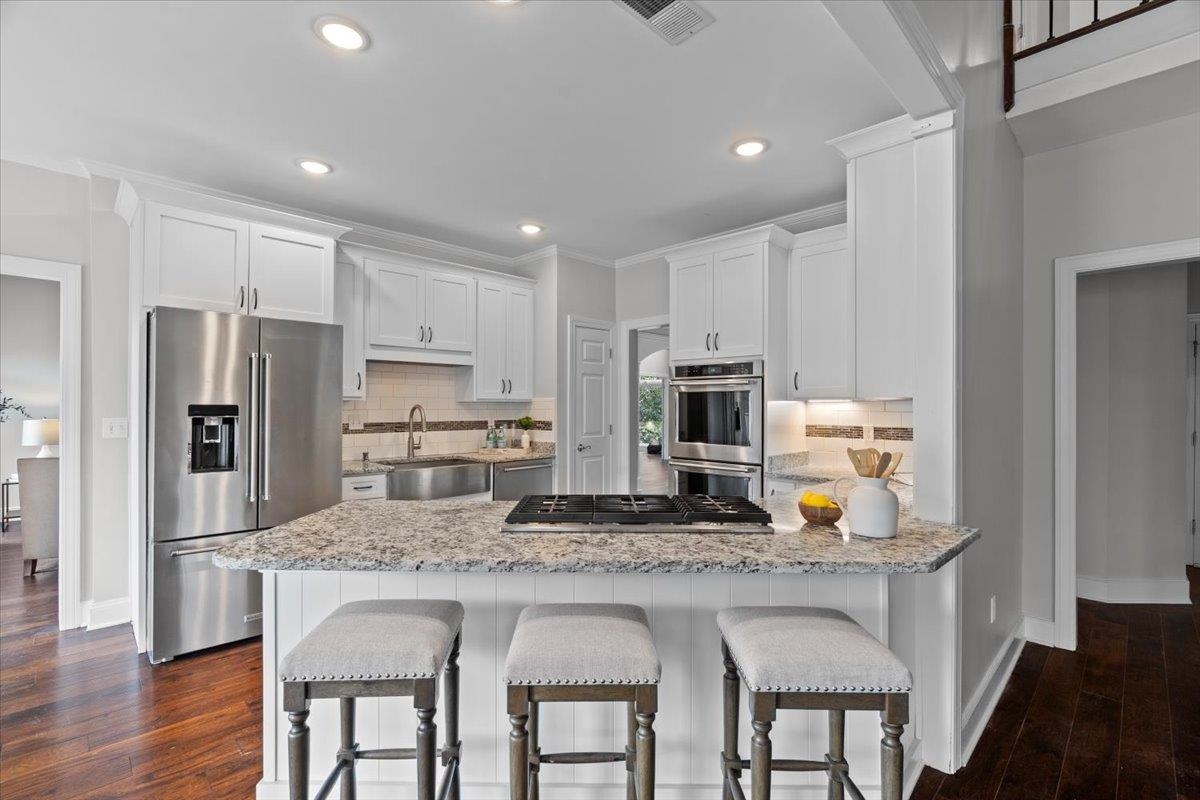10440 Ansley Cove Collierville, TN 38017 - Photo 13 of 40 a kitchen with granite countertop a refrigerator stove microwave and wooden floor