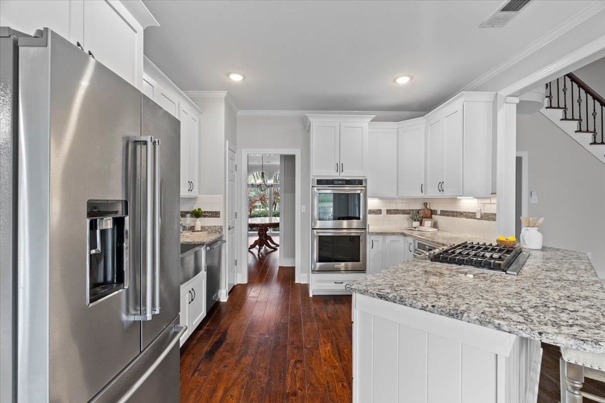 10440 Ansley Cove Collierville, TN 38017 - Photo 14 of 40 a kitchen with stainless steel appliances granite countertop a refrigerator a stove and a sink with wooden floor