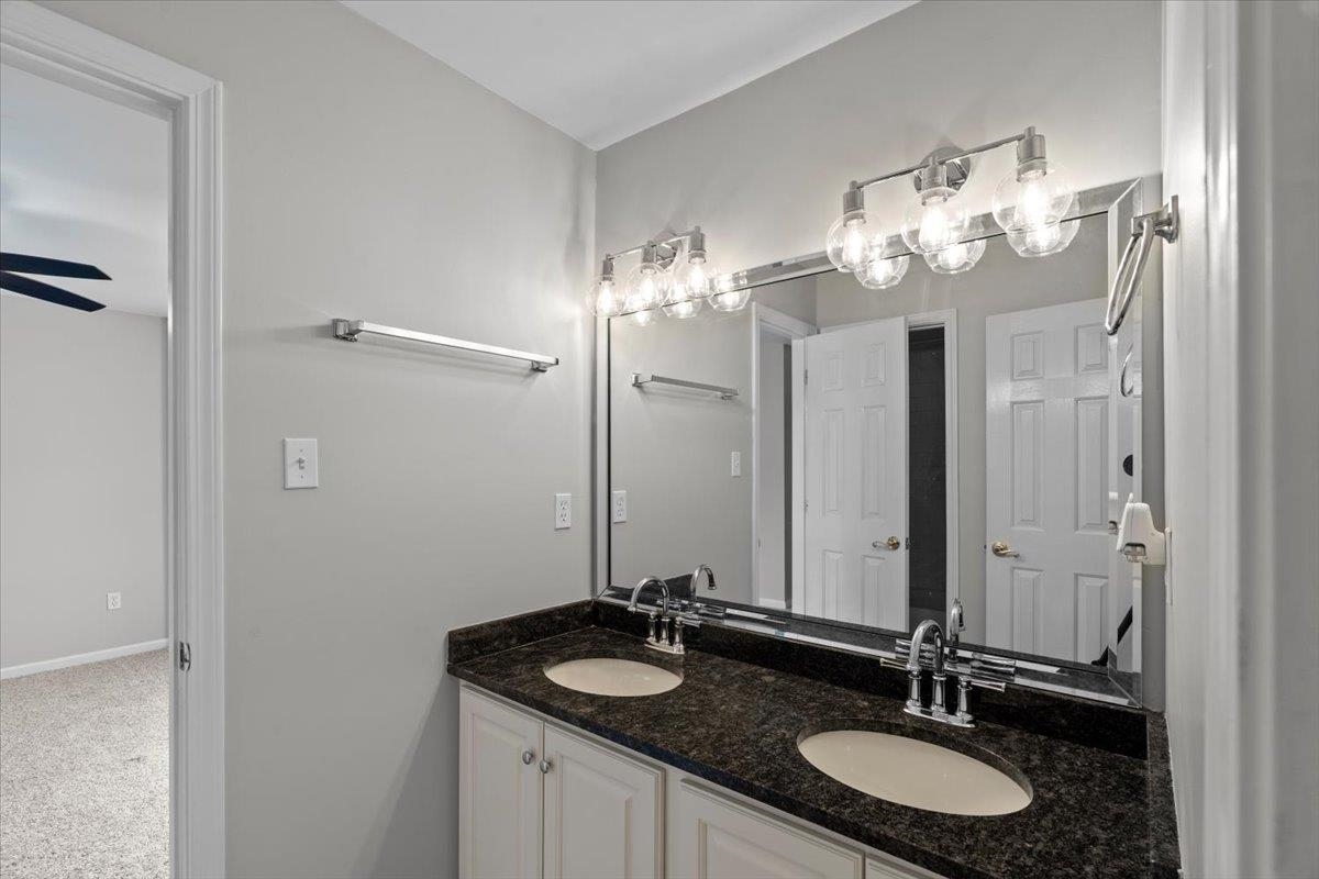 10440 Ansley Cove Collierville, TN 38017 - Photo 27 of 40 a bathroom with a granite countertop sink and a mirror