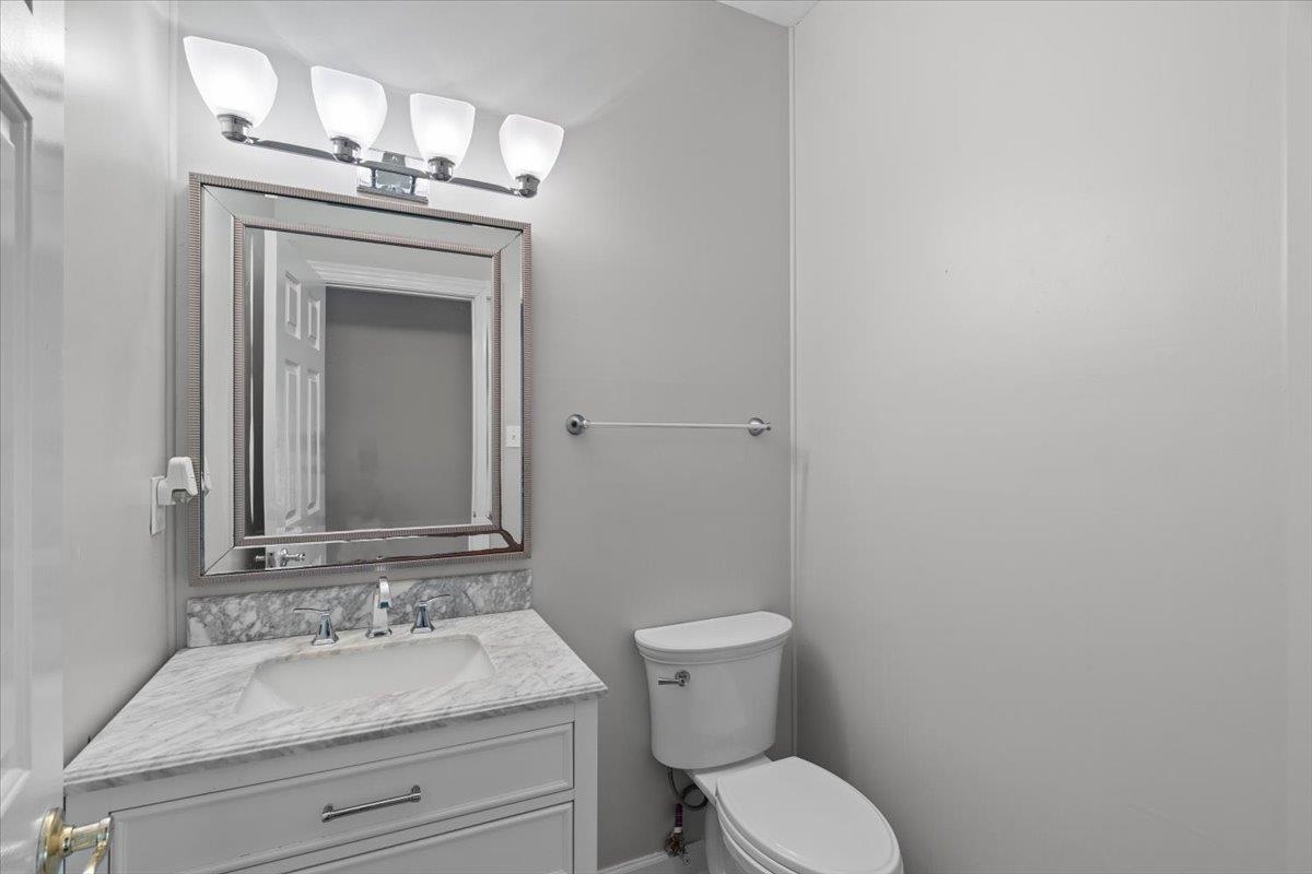 10440 Ansley Cove Collierville, TN 38017 - Photo 35 of 40 a bathroom with a granite countertop toilet a sink and mirror