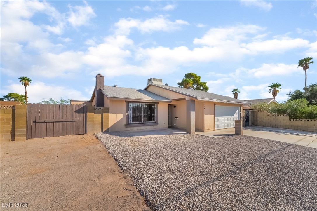 2246 East Russell Road Las Vegas, NV 89119 - Photo 1 of 24 View of front facade with driveway, a gate, roof with shingles, a garage, and a chimney