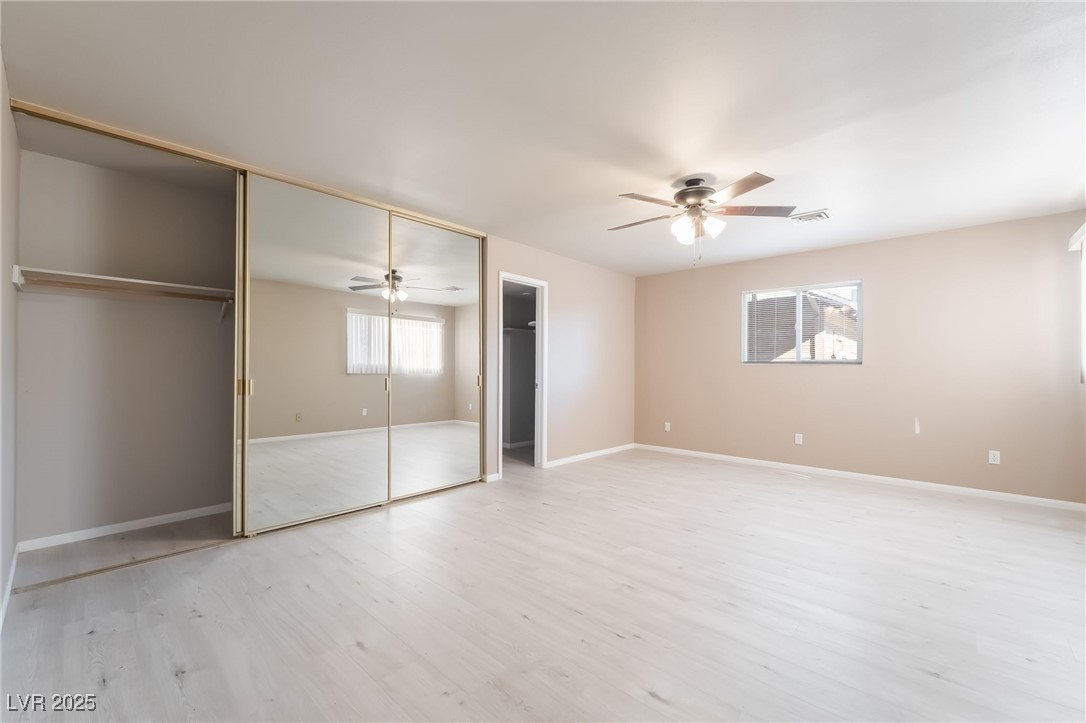 2246 East Russell Road Las Vegas, NV 89119 - Photo 11 of 24 Unfurnished bedroom with light wood finished floors, a ceiling fan, and a closet