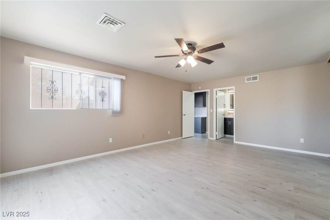 2246 East Russell Road Las Vegas, NV 89119 - Photo 12 of 24 Unfurnished bedroom with light wood-style floors, ceiling fan, and ensuite bath