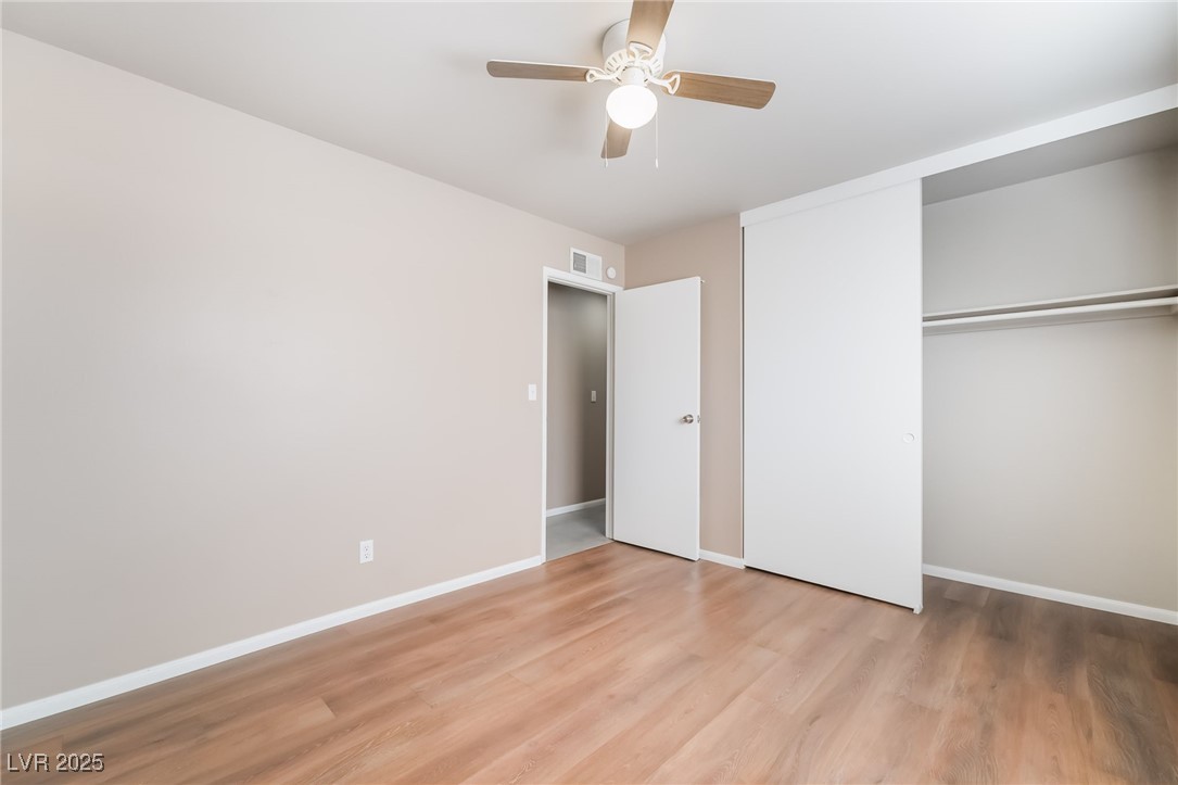 2246 East Russell Road Las Vegas, NV 89119 - Photo 15 of 24 Unfurnished bedroom with light wood-type flooring, a ceiling fan, and a closet