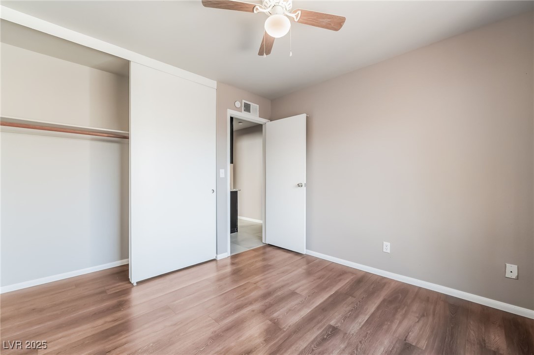 2246 East Russell Road Las Vegas, NV 89119 - Photo 18 of 24 Unfurnished bedroom featuring wood finished floors, a closet, and a ceiling fan