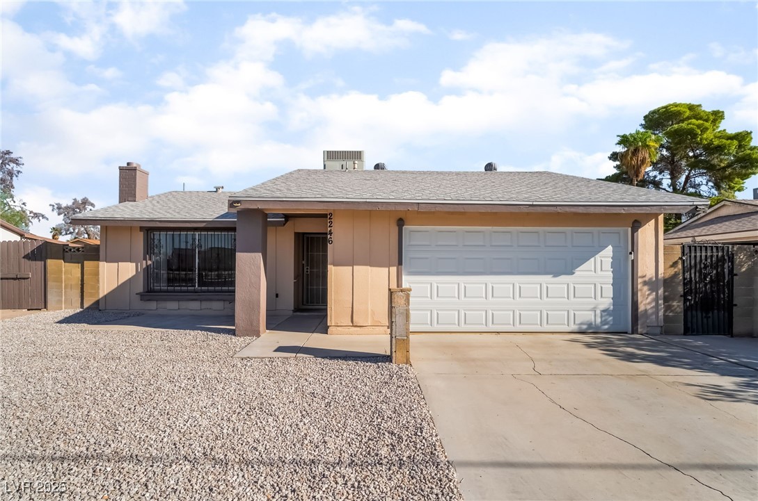 2246 East Russell Road Las Vegas, NV 89119 - Photo 23 of 24 Ranch-style house featuring a gate, concrete driveway, a chimney, roof with shingles, and a garage