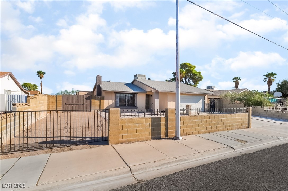 2246 East Russell Road Las Vegas, NV 89119 - Photo 24 of 24 Bungalow-style home featuring a fenced front yard, concrete driveway, an attached garage, and a chimney