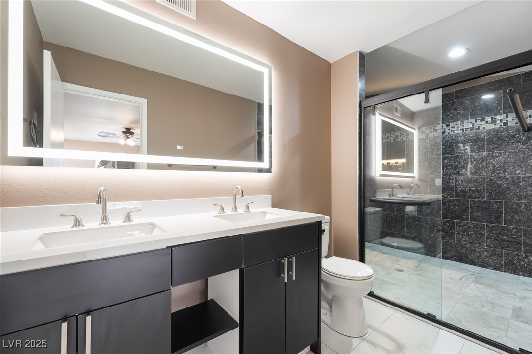 2246 East Russell Road Las Vegas, NV 89119 - Photo 5 of 24 Bathroom with walk in shower, double vanity, and a ceiling fan